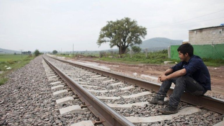 Migrant Santos Tome Hernandes, 16, from Honduras, sits on the railway tracks in Huehuetoca, outskirts of Mexico City 26 June 2014