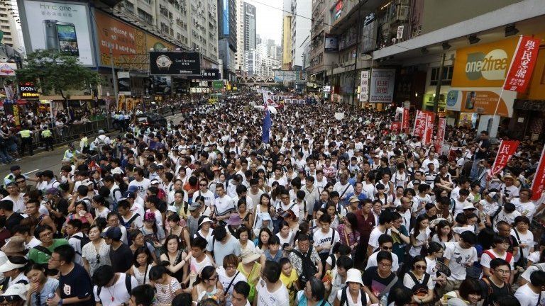 Protesters fill in a street during a march at an annual protest in downtown Hong Kong, 1 July 2014