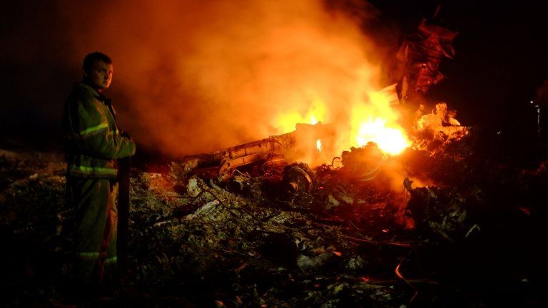 A firefighter stands as flames burst amongst the wreckages of the malaysian airliner carrying 298 people from Amsterdam to Kuala Lumpur after it crashed, near the town of Shaktarsk, in rebel-held east Ukraine, on 17 July 2014