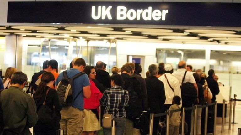 People queuing at the UK border in an airport