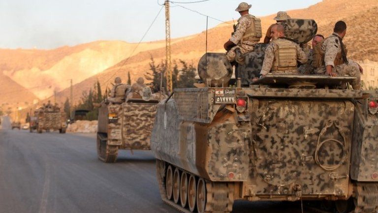 Lebanese army armoured personal carriers (APC) drive to the entrance of the town of Arsal in the Bekaa valley on 2 August 2014
