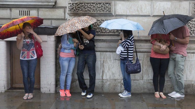 Pedestrians sheltering from rain