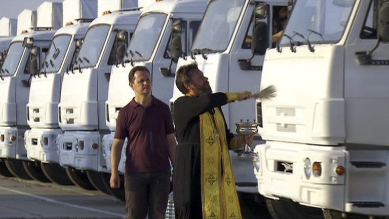 A priest blesses Russian aid lorries in Alabino, outside Moscow, 12 August