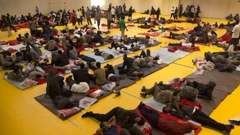 African migrants rest inside a sports centre in Tarifa, Spain, 13 August
