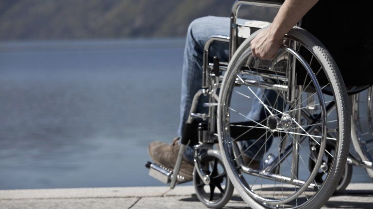 Man in a wheelchair by water