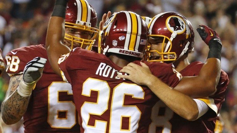 Washington Redskins tackle Tom Compton (68) and quarterback Kirk Cousins (8) celebrate with running back Evan Royster (26), after Royster's touchdown during the first half of an NFL preseason football game 18 August 2014
