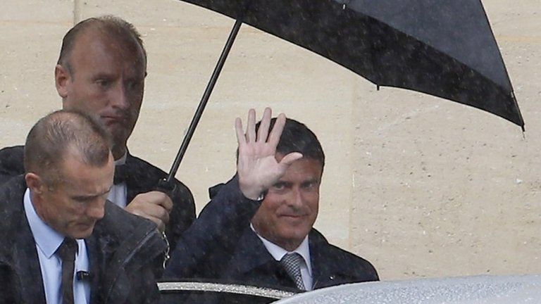 French Prime Minister Manuel Valls waves as he leaves the Hotel Matignon in Paris, 26 August