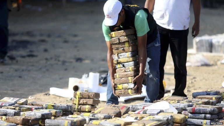 Workers move blocks of cocaine confiscated from a stone coal storage in Trujillo on 26 August, 2014.