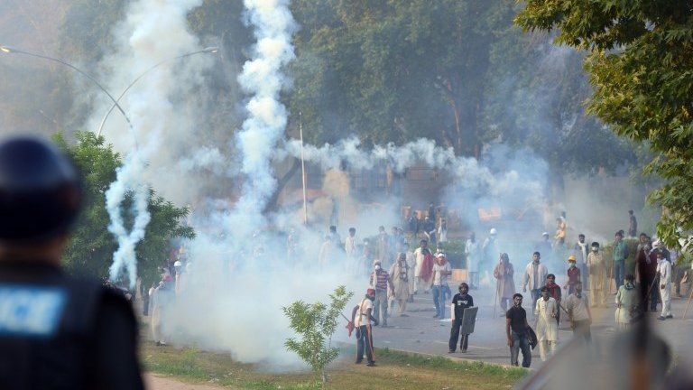 Pakistani protesters stand amongst tear gas during clashes with police in Islamabad. Photo: 31 August 2014