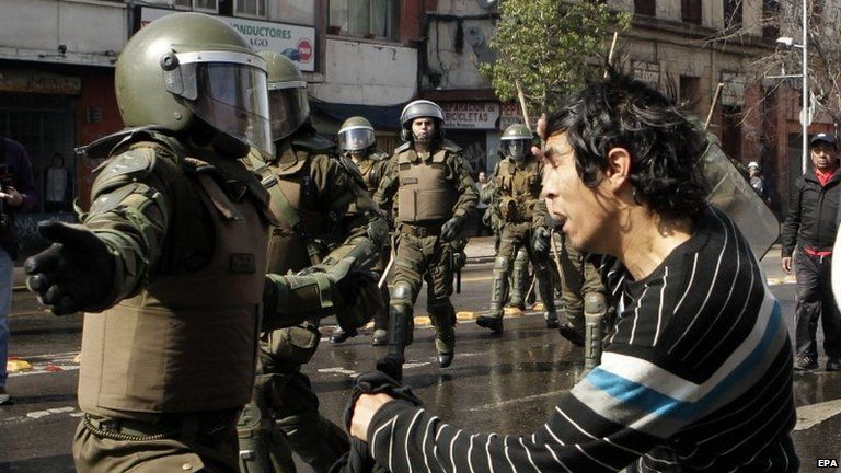A protester clashes with police after a march to the memorial of "The Disappeared-Detained" in Santiago on 7 September