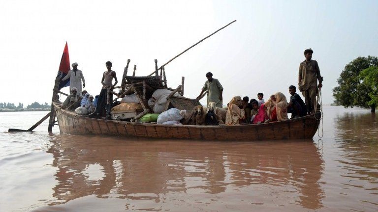 Pakistani volunteers from the Falah-i-Insaniat Foundation (FIF), which is closely linked to Islamic hardline organisation Jamaat ud Dawa (JuD), use a boat to rescue flood-affected residents from a village on the outskirts of Multan, in the central Punjab province on September 9, 2014.