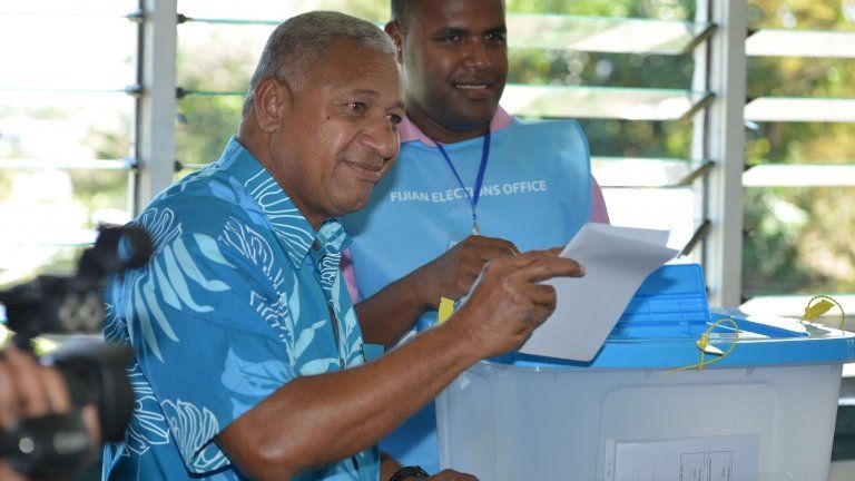 This photo taken on 17 September 2014 shows Fiji's military strongman Voreqe "Frank" Bainimarama (L) casting his election vote at the Vatuwaqa Public School in the capital Suva