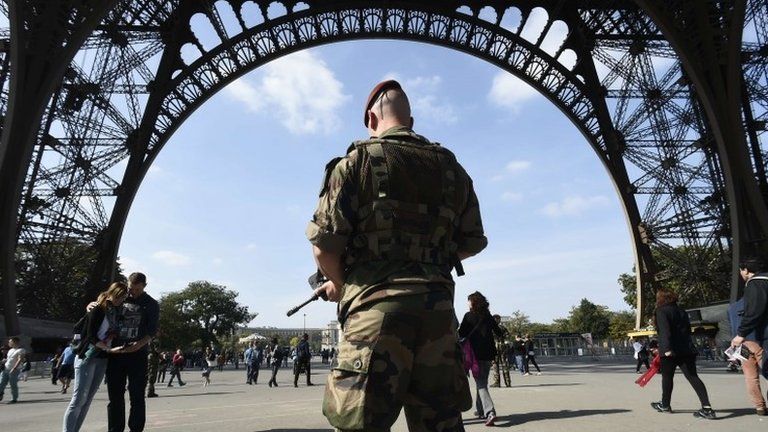 A French paratrooper patrols near the Eiffel Tower in Paris, 23 September