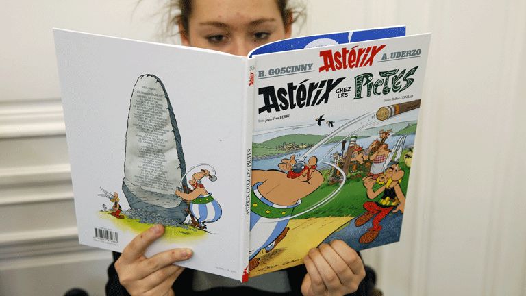 A girl reads Asterix And The Picts just after its release in Paris, 23 October 2013