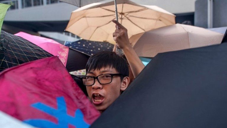 Protesters hide behind umbrellas outside Hong Kong's government complex on 27 September 2014