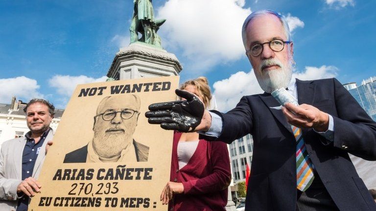 Protesters mock Spain's Miguel Arias Canete in front of the European Parliament in Brussels, 1 October