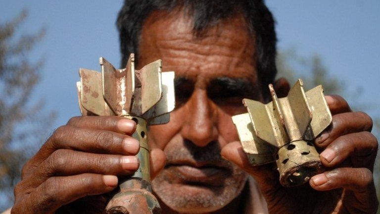 A Pakistani Kashmiri man displays mortar shrapnel allegedly fired across the Line of Control (LoC) between Pakistan and India, in the Kotli sector of Pakistan-administrated Kashmir on October 8, 2014.