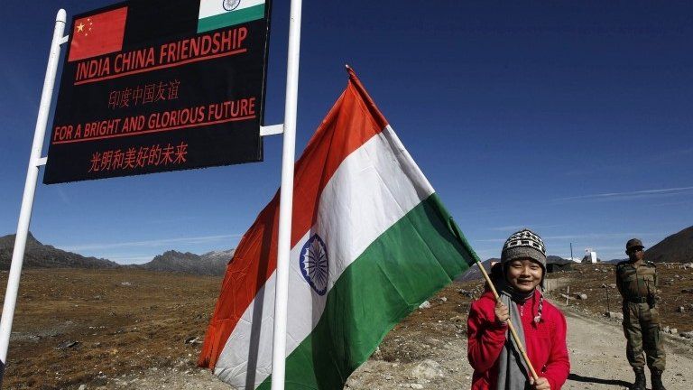 An Indian girl poses for photos with an Indian flag at the Indo China border in Bumla at an altitude of 15,700 feet (4,700 meters) above sea level in Arunachal Pradesh, India.
