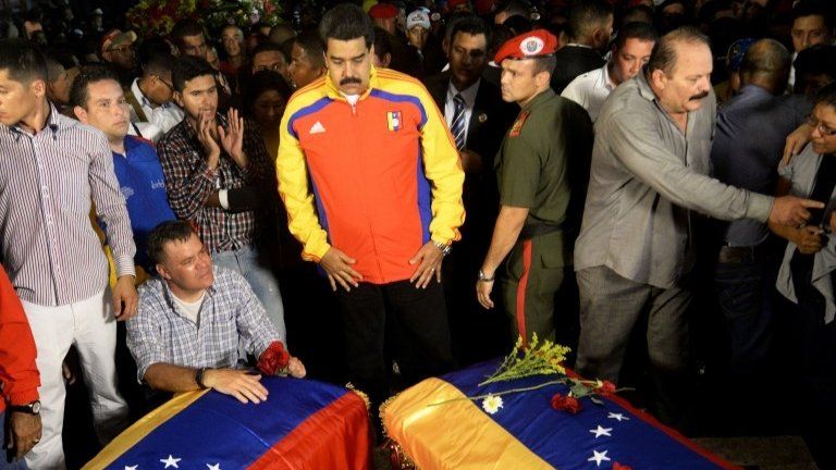 Venezuelan President Nicolas Maduro (C) stands before the coffins of Robert Serra and Mari­a Herrera during their funeral in Caracas on 3 October, 2014.