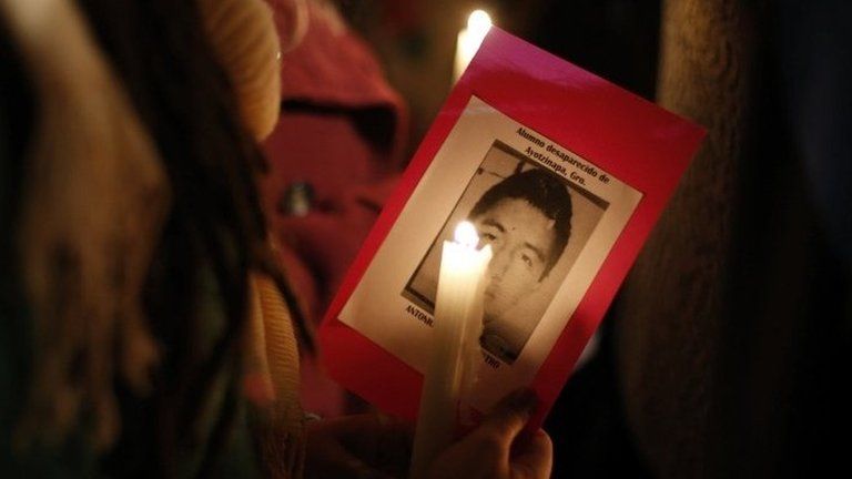 A student holds a picture of one of the missing trainee teachers at a vigil in Mexico City on 14 October, 2014.