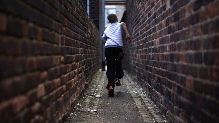 Boy running through narrow streets