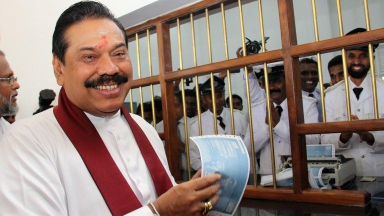 Sri Lankan President Mahinda Rajapaksa (R) after buying the first ticket for the Yal Devi train at the newly reconstructed railway station in Jaffna, Sri Lanka, 13 October, 2014