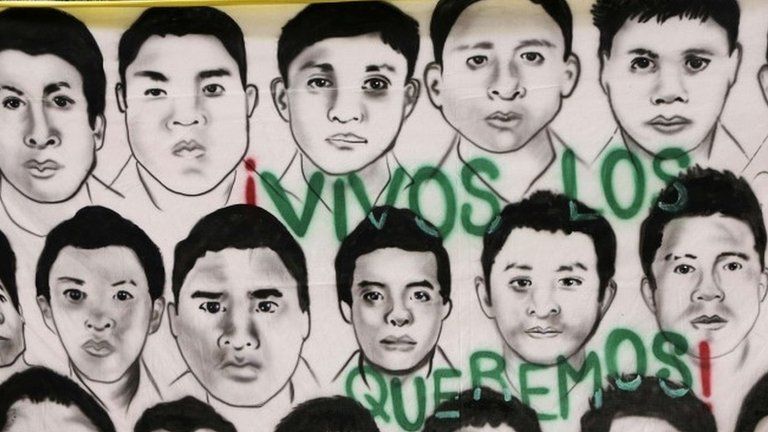 A banner reading "We want them alive" with portraits of 43 missing students hangs outside their Ayotzinapa Teacher Training College in Tixtla, near Chilpancingo, in the southwestern state of Guerrero, on 10 November, 2014.