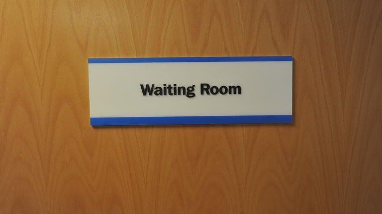 Waiting room sign on GP surgery door