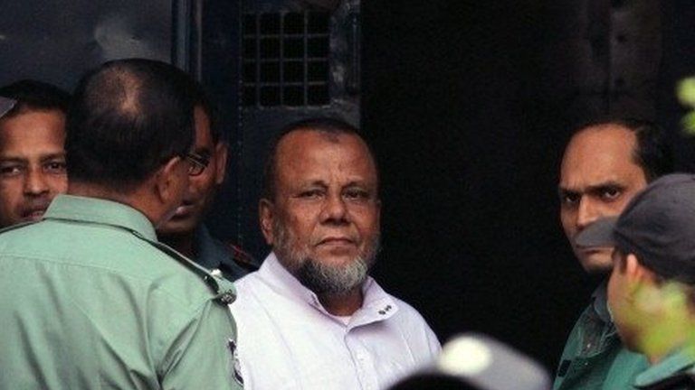 Bangladesh former ruling party official Mobarak Hossain (C) looks on as he enters a van at the International Crimes Tribunal court in Dhaka on November 24, 2014.