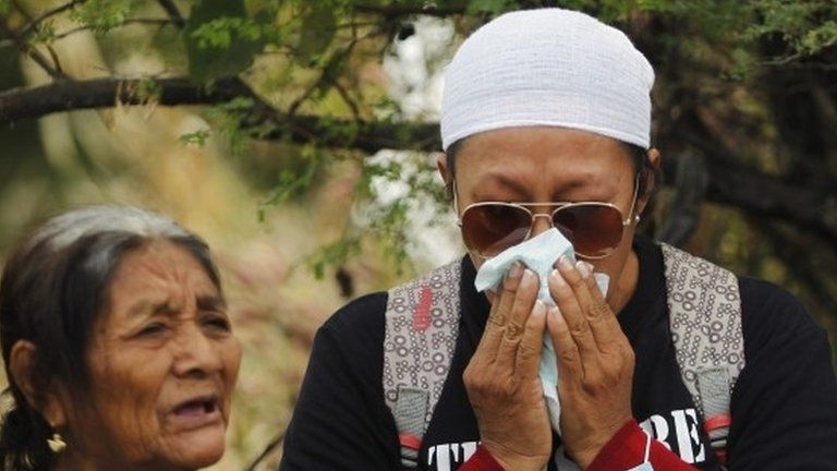 A woman with missing relatives is struck by grief during a religious mass before a search in a graves zone discovered in October outside Iguala, in Guerrero state on 29 November 2014.