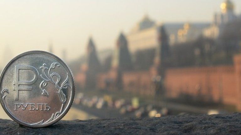 A Russian ruble coin is pictured in front of the Kremlin in central Moscow,
