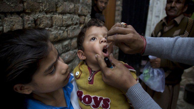 A Pakistani health worker gives a polio vaccine to a child in Islamabad, Pakistan, Monday, Dec. 8, 2014.