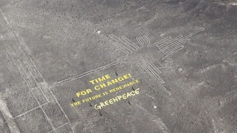 A climate change banner is seen beside the Nazca lines located on a stretch of coastal desert in Peru, in this handout photo released on 8 December 2014, by Greenpeace
