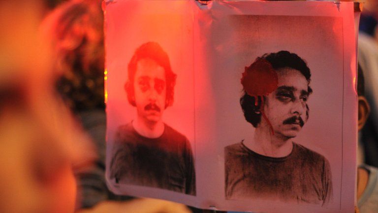 A demonstrator holds a picture of a disappeared relative during a protest outside the Military Club in Rio de Janeiro on 29 March, 2012
