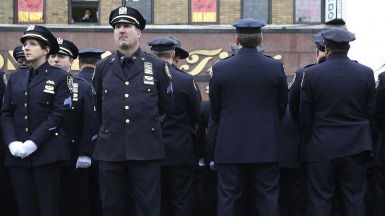 Some police officers turn their backs on a video screen showing Mayor Bill de Blasio speaking the funeral in New York of Wenjian Li, 4 January