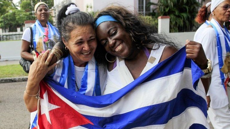 Recently released dissidents Aide Gallardo (left) and Sonia Garro hold the Cuban national flag during a march in Havana on 11 Januaryy, 2015
