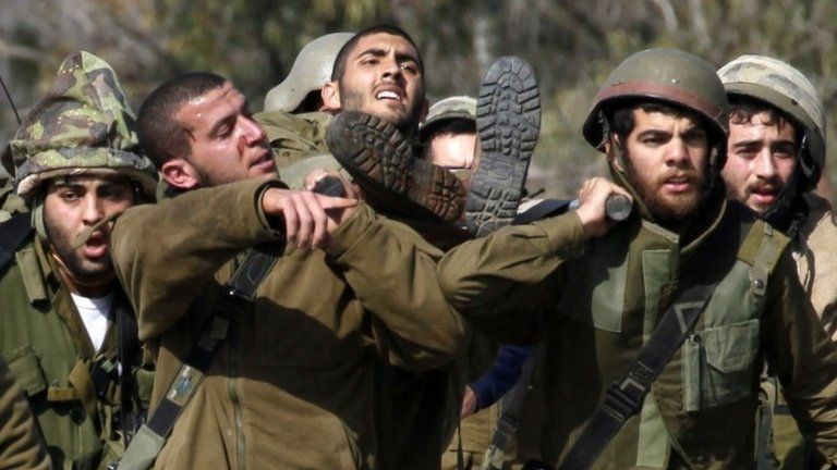 Israeli soldiers carry a wounded comrade near the Lebanese border (28 January 2015)