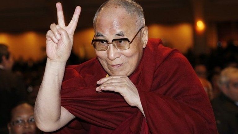 The Dalai Lama directs a peace sign toward the head table, where U.S. President Barack Obama was seated, during the National Prayer Breakfast in Washington 5 February 2015