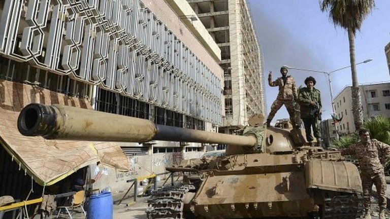 Members of the Libyan pro-government forces, backed by locals, gather on a tank outside the Central Bank, near Benghazi port, 21 January 2015