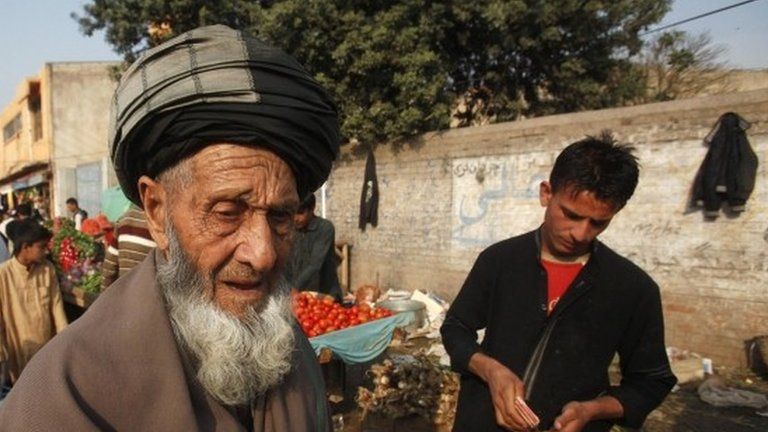 An elderly Afghan refugee man, who have residency a card which will expire on December 2015, walks along a market on the outskirts of Peshawar February 18, 2015.