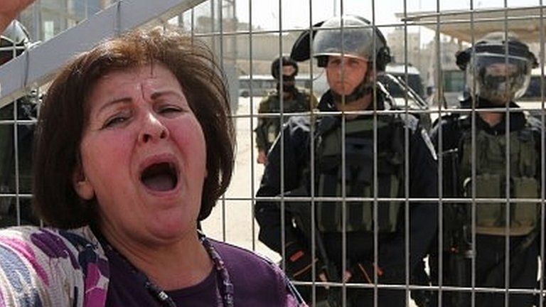 Palestinian woman shouts in front of Israeli soldiers at Qalandiya checkpoint between Jerusalem and Ramallah (07/03/15)