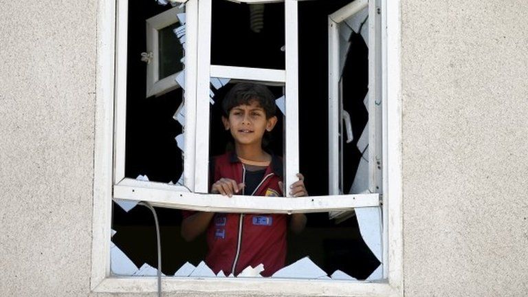 A boy looks out the window of a home damaged in an air strike near Sanaa's airport (31 March 2015)