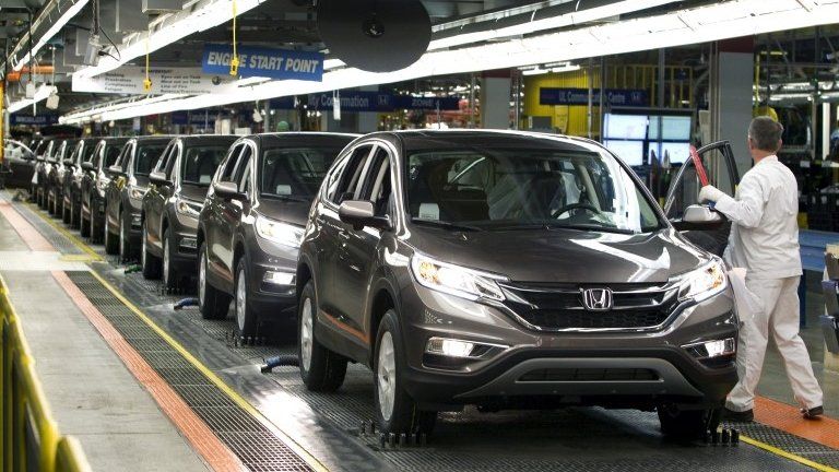 Production Associates inspect cars moving along assembly line at Honda manufacturing plant