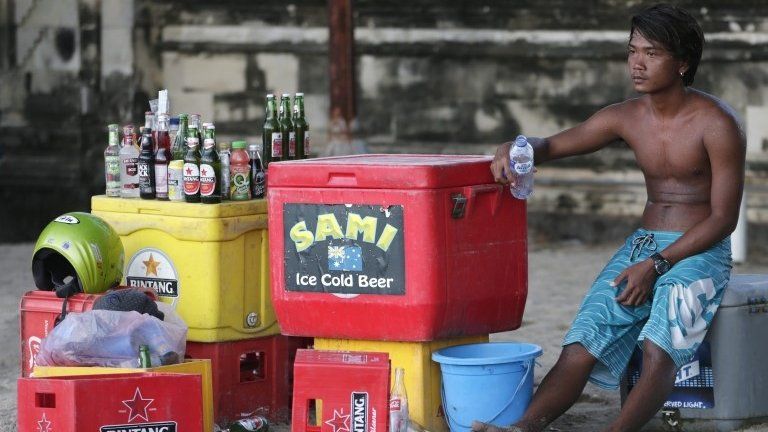 A man sells beer on the beach in Kuta, Bali (15 April 2015)