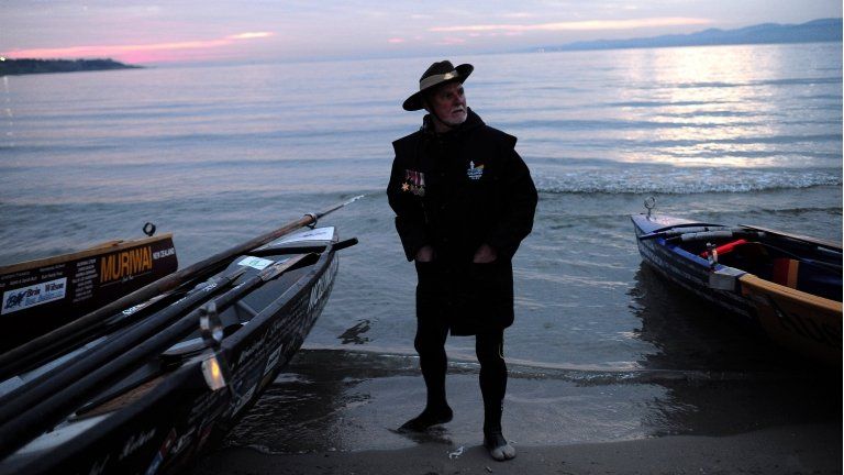 Australian man stands by boats at Gallipoli, 25 April 2015