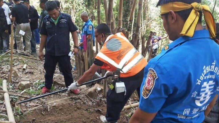 Rescue workers and forensic officials inspect the site of a mass grave at an abandoned jungle camp in Thailand's southern Songkhla province bordering Malaysia on 1 May 2015.