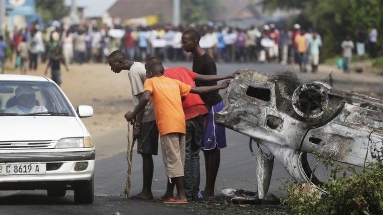 Demonstrators check a vehicle at a checkpoint they man on a street barricade in Bujumbura, Burundi, on 1 May