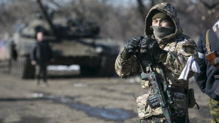 File photo: A fighter with the separatist self-proclaimed Donetsk People's Republic Army stands guard at a checkpoint along a road from the town of Vuhlehirsk to Debaltseve in Ukraine, 18 February 2015