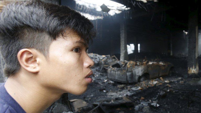 A boy looks into the gutted factory in Valenzuela, Metro Manila (14 May 2015)