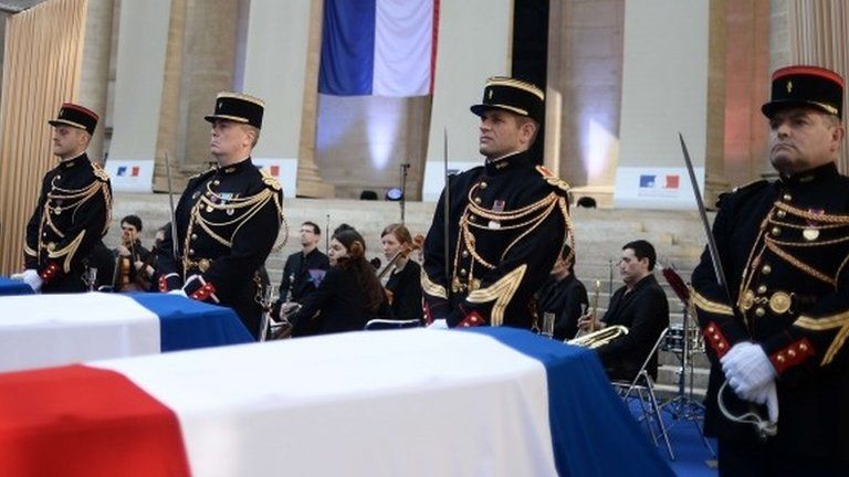 Members of French Republican Guard stand guard next to the coffins of French Resistants during World War II whose portraits hang on the columns - May 27, 2015